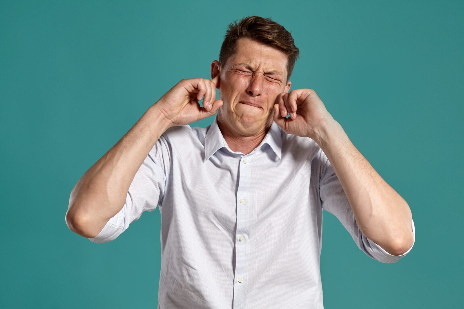 Person touching ear in distress representing tinnitus